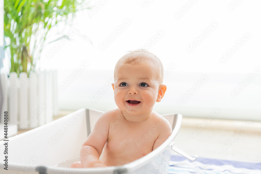 Happy and smiling caucasian baby inside a portable bathtub. Happy and smiling caucasian baby inside a portable bathtub.