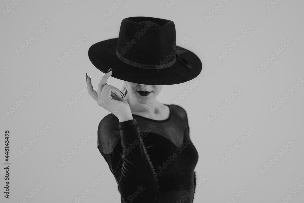 Charming woman posing with black hat on white background. Femme fatale  costume, stylish outfit. Black and white. Sexy model dancer. foto de Stock  | Adobe Stock