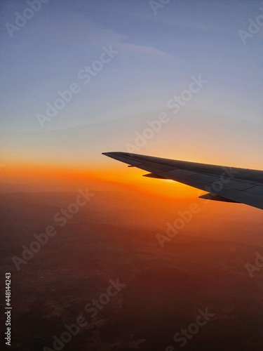 View of the sky and the wing with the iluminator of the aircraft. Lovely sunset, mountains and atmosphere of travel.