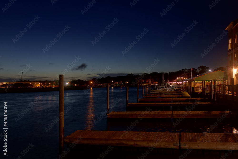 View of Southport NC riverfront at dusk with boat docks and seafood restaurants