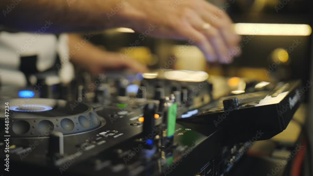 Close-up of the DJ's hands working at the remote control. A party at a bar or club. Close-up of the DJ's hands working at the remote control. A party at a bar or club.