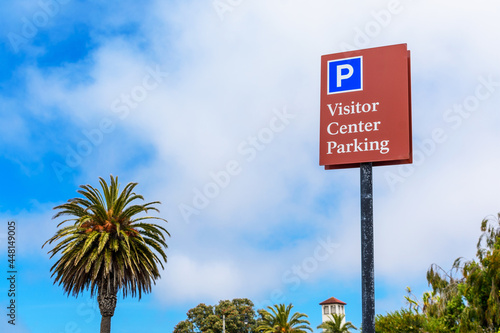 Visitor Center Parking sign. Palm tree, Overcast