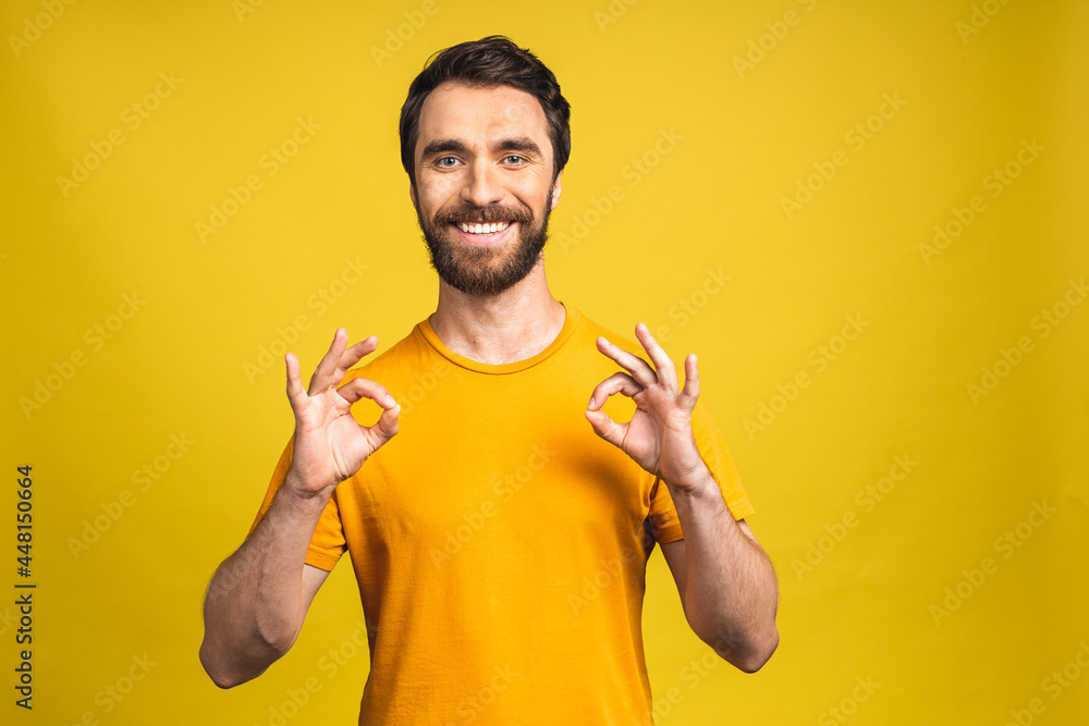 A handsome young man in casual isolated on pink background showing ok sign. A handsome young man in casual isolated on pink background showing ok sign.