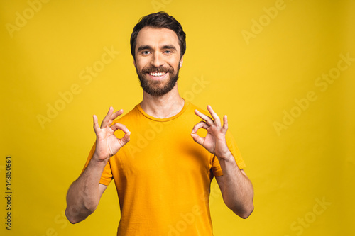 A handsome young man in casual isolated on pink background showing ok sign.