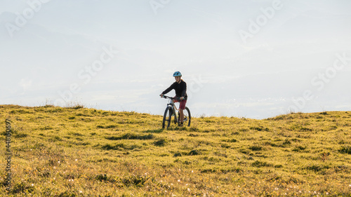 Girl child riding mountain bike at sunset. Beautiful golden summer light.