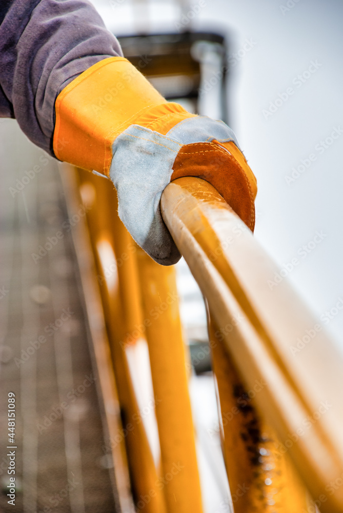 gloved hand holding the handrail as an industrial safety standard in a quarry