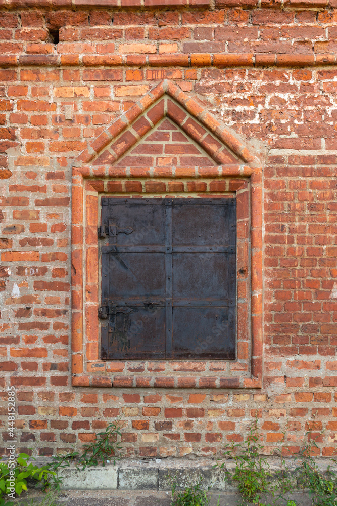 medieval window with iron shutters in a brick wall medieval window with iron shutters in a brick wall