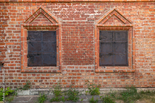 medieval window with iron shutters in a brick wall
