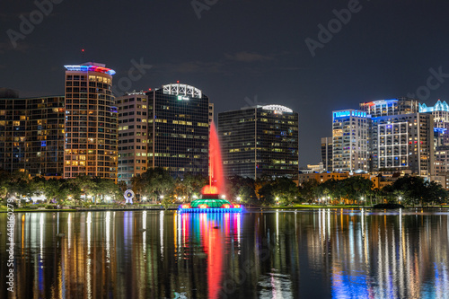 Nightime photo of Lake Eola in downtown Orlando with the colorful fountain and reflections on the water