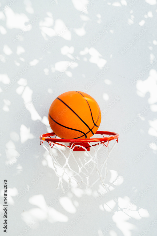 Basketball hoop on a white wall. The ball about to enter the ring. Basketball hoop on a white wall. The ball about to enter the ring.