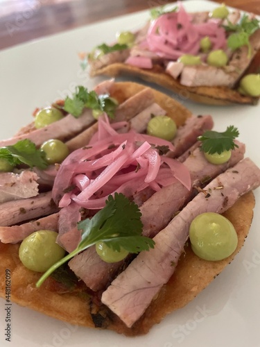 Tacos de carne ahumada acompañada de cebolla morada, aceitunas, cilantro y un poco de chile serrano en tortilla de maíz