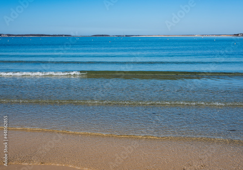 Seascape with flat waves rolling in on the shallow sea water