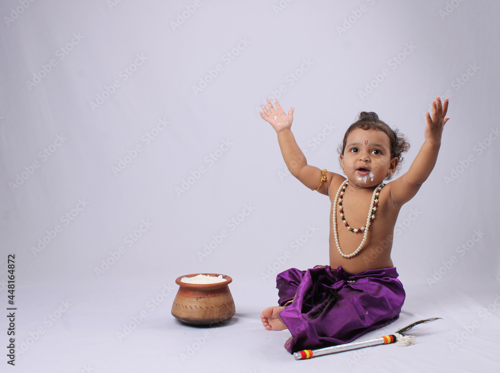 Φωτογραφία adorable Indian baby in krishna kanha or kanhaiya dress posing with his flute and dahi handi (pot with curd) on white background