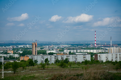An industrial city on the horizon against the backdrop of a cloudy sky.
