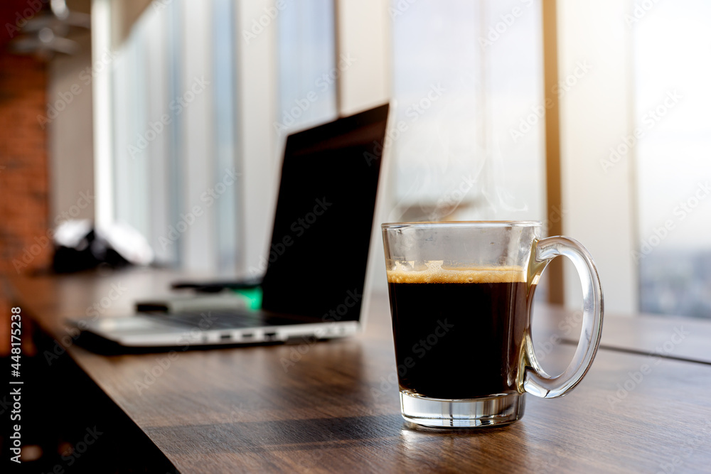 Cup of hot coffee on wooden table with computer Cup of hot coffee on wooden table with computer
