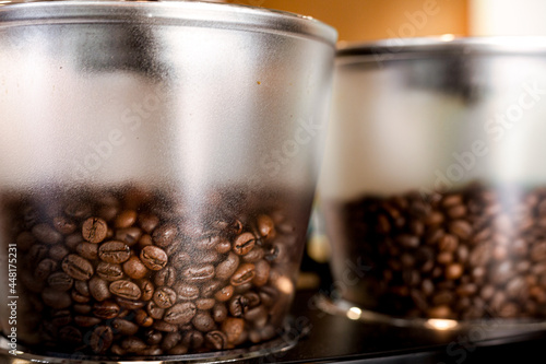 Close up coffee beans in a machine jar