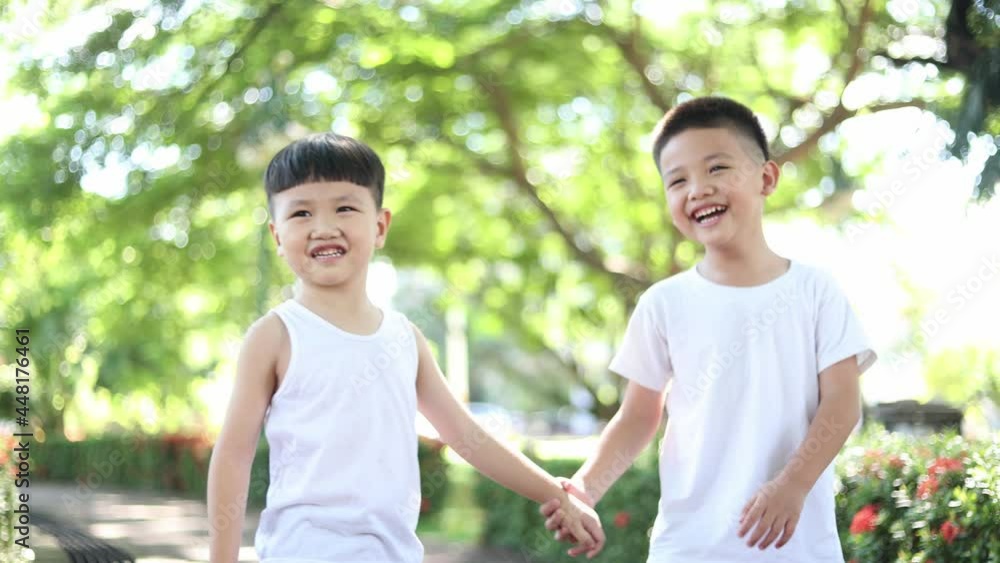 Happy two Asian boys dressed in white in the park Happy two Asian boys dressed in white in the park