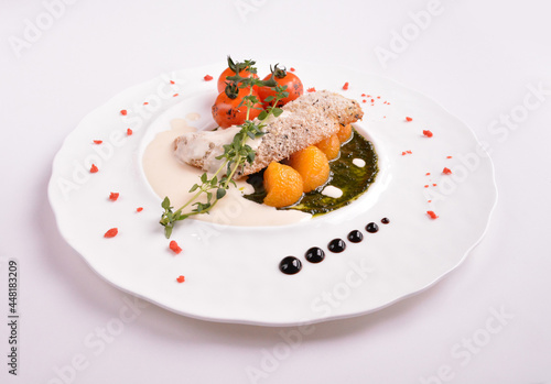 deep fried bake bread fish fillet seafood with orange and tomato in chef rosemary sauce and vegetables in white background for Christmas festival menu