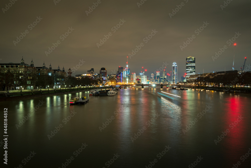 A long exposure photo of Thames river at night in London, UK