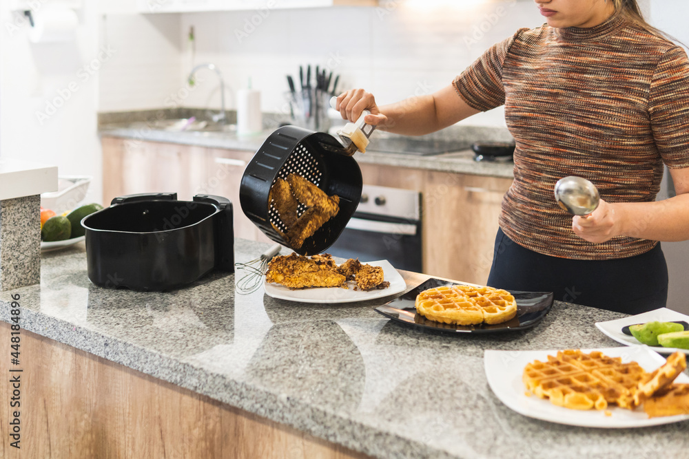 Obraz na plátně woman serving fried chicken with air fryer waffles
