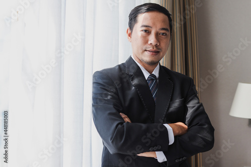 Successful asian businessman standing with arms crossed