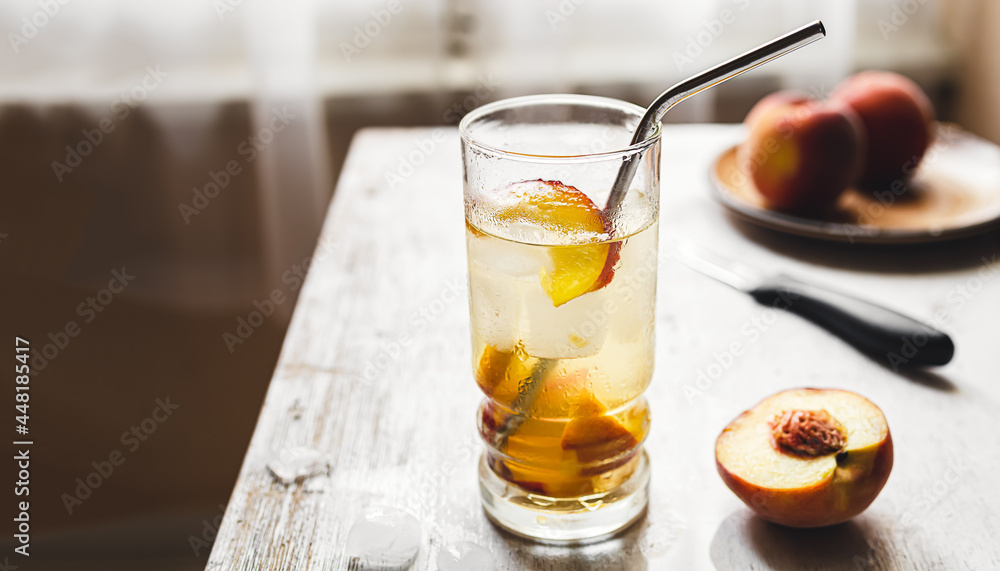 Peach summer refreshing beverage and fresh peaches on an old white wooden table by the window Peach summer refreshing beverage and fresh peaches on an old white wooden table by the window