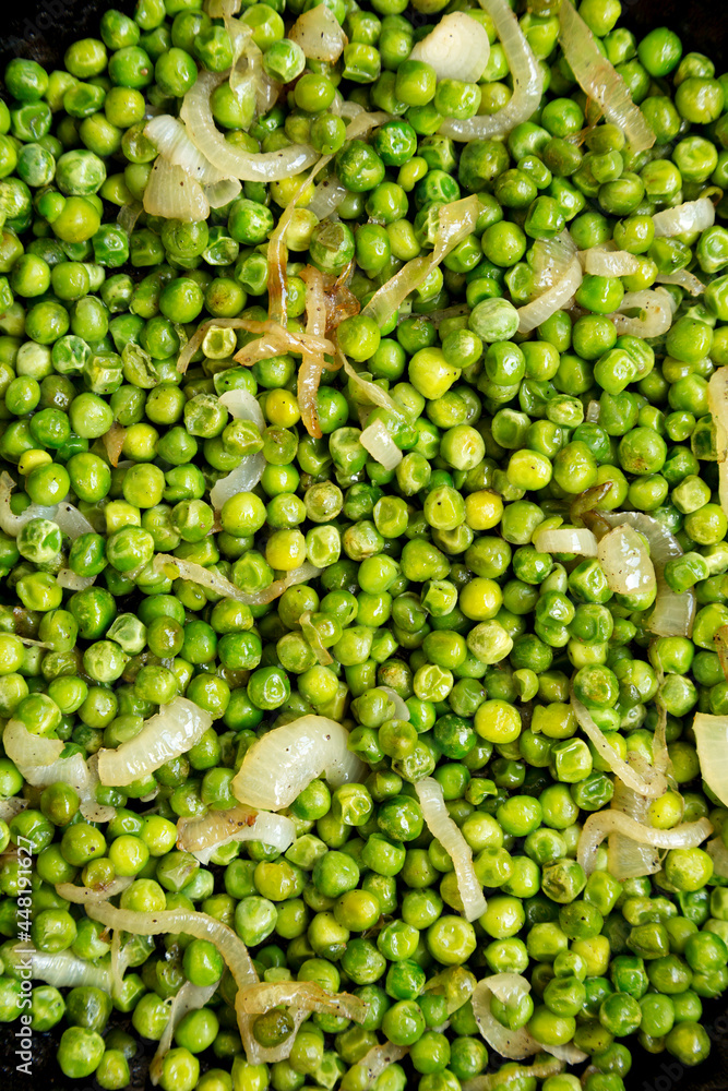 Homemade Sauteed Green Peas in a cast-iron pan, overhead view. Flat lay, top view, from above. Close-up. Homemade Sauteed Green Peas in a cast-iron pan, overhead view. Flat lay, top view, from above. Close-up.