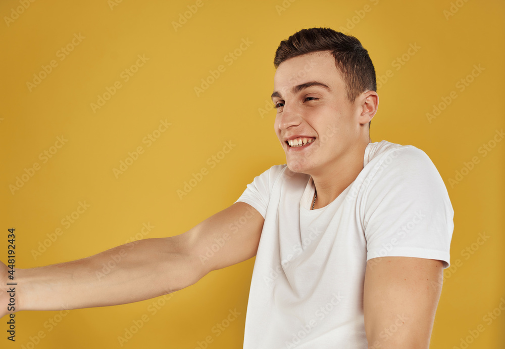 man in white t-shirt gesturing with his hands yellow background man in white t-shirt gesturing with his hands yellow background