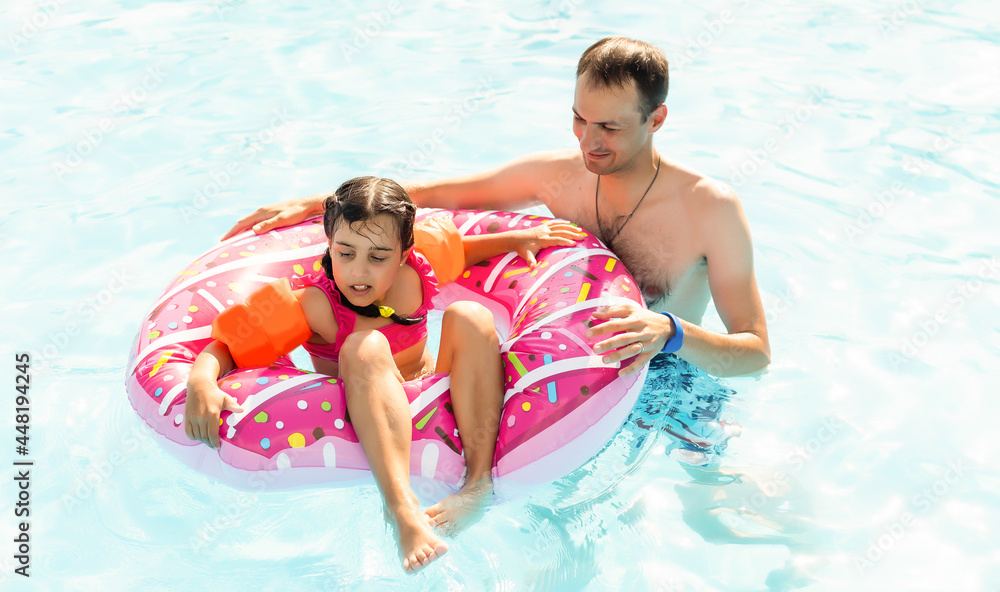Happy family playing in swimming pool. Summer vacation concept Happy family playing in swimming pool. Summer vacation concept