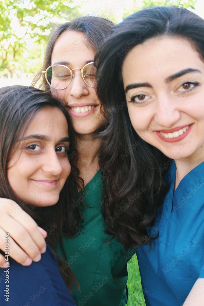 Team portrait of healthcare worker friends / intern doctors / medical student women together & smiling happy Team portrait of healthcare worker friends / intern doctors / medical student women together & smiling happy