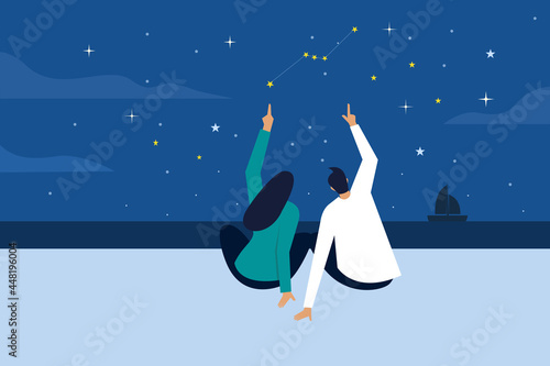 Man and a woman watching stars in a beach at night