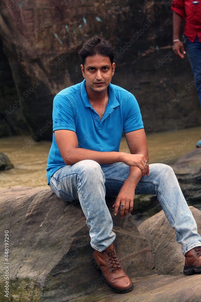 Handsome attractive man at river bank with river on background, looks at camera with calm and smiling expression. Handsome attractive man at river bank with river on background, looks at camera with calm and smiling expression.