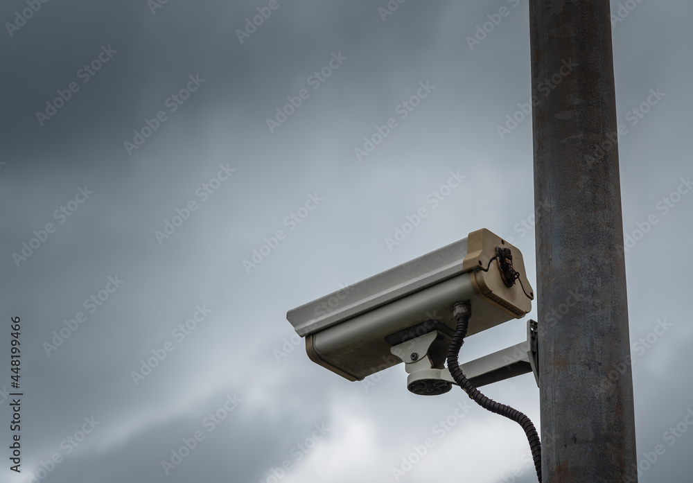 CCTV security camera in overcast dark cloudy sky. CCTV security camera in overcast dark cloudy sky.
