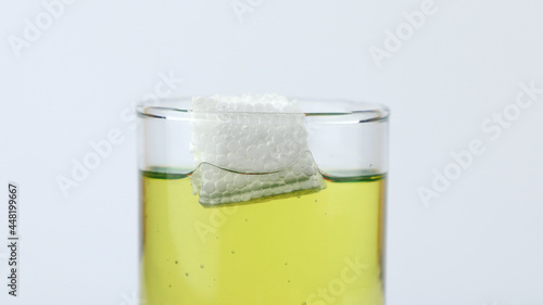 Styrofoam floats on olive oil, demonstration of density experiment with liquid. The science concept of density photo