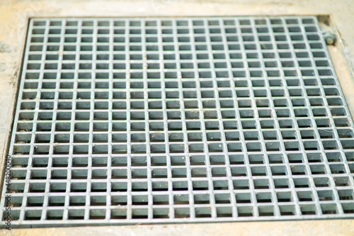 Closeup drain sump and grating on the floor in outdoor.
