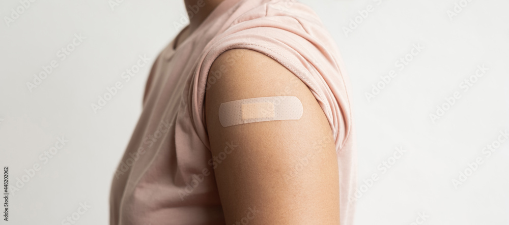 Φωτογραφία Asian woman shows plaster on her shoulder after being vaccinated against Covid-19