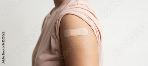 Slika na platnu Asian woman shows plaster on her shoulder after being vaccinated against Covid-19