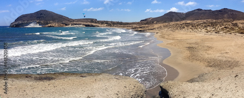 A kitesurfer enjoying his hobby on the lonely beach called 