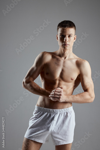 athlete with inflated torso joined hands near chest on gray background cropped view