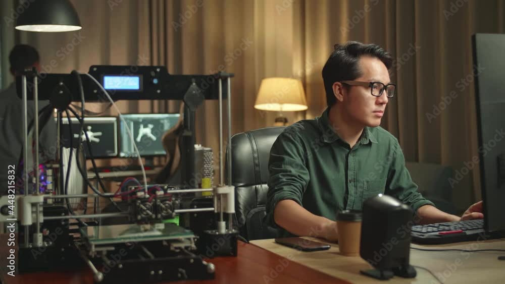 Asian Man Works On Personal Computer And 3D Printer In Home Office, He Works At Night
Asian Man Works On Personal Computer And 3D Printer In Home Office, He Works At Night