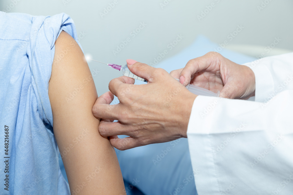 Doctor giving patient vaccine, COVID-19, flu or influenza shot. Vaccination and prevention against flu, Covid-19 virus pandemic with syringe at hospital room.