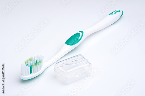 white-green toothbrush on a white background. Oral health. Personal hygiene.