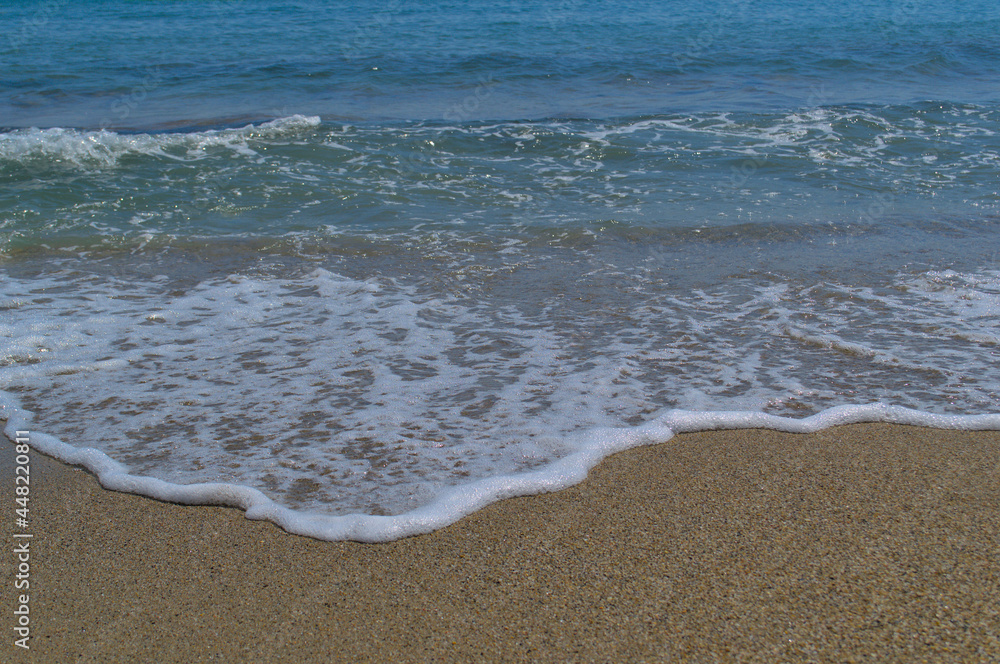 Sandy beach, beautiful sea waves. White sea foam.