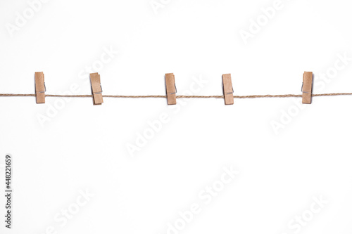 wooden clothespins on a rope on a white background  mock-up for design  copy space  rustic vintage style  clothesline for drying clothes with clothespins