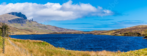 A view across Loch Leathan with the Old Man of Storr rock formation visible in the distance on the Isle of Skye, Scotland on a summers day