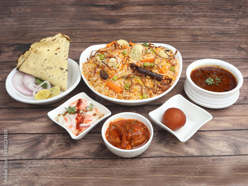 Veg Biryani Thali - Basmati rice cooked with veggies and spices and served with mirchi ka salan,raita,sweet and papad. selective focus