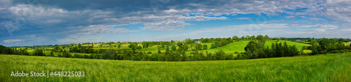 Rich, verdant, green rolling agricultural fields near Markethill in County Armagh in Northern Ireland, UK. A panoramic view taken on a sunny day in summer with light clouds. photo