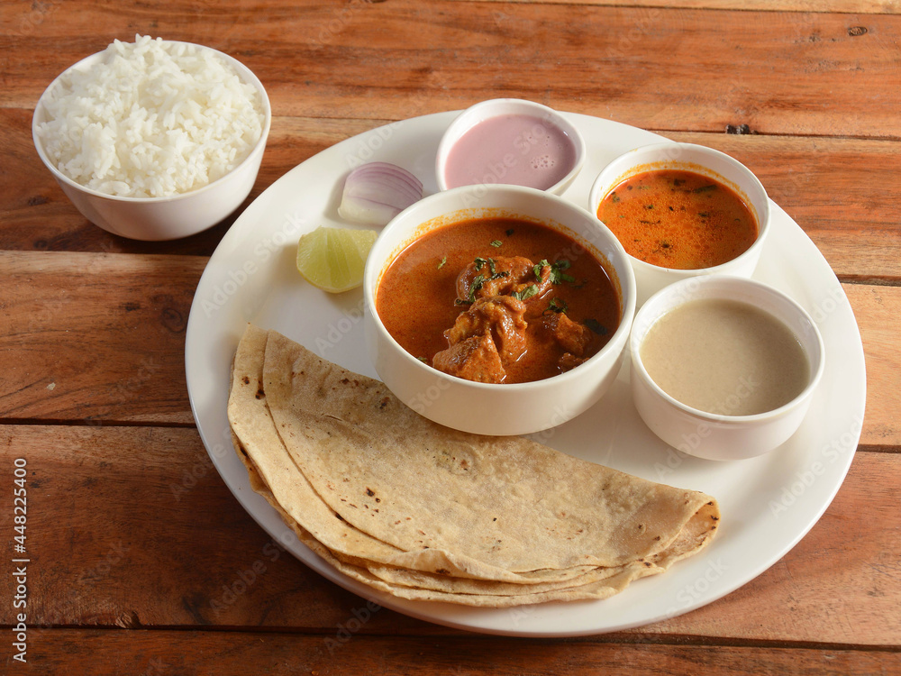 Chicken Thali from an indian cuisine, food platter consists of Chicken curry, lentils, steamed rice, curd and onions., selective focus Chicken Thali from an indian cuisine, food platter consists of Chicken curry, lentils, steamed rice, curd and onions., selective focus