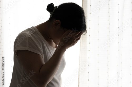 頭を抱える若い女性（日本人、30代）