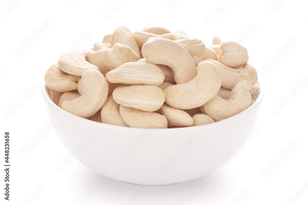Close-up Organic dry fruit cashew nut (Anacardium occidentale) in white ceramic bowl on white background Close-up Organic dry fruit cashew nut (Anacardium occidentale) in white ceramic bowl on white background